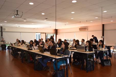 Foto del salón de clases, durante una lección, todos sentados ponen atención al profesor.