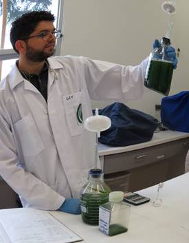 Investigador del CICA en el laboratorio mientras realiza análisis con una pipeta en la mano