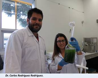 Dr. Carlos Rodríguez posa en el laboratorio en compañía de una investigadora, ambos de pie