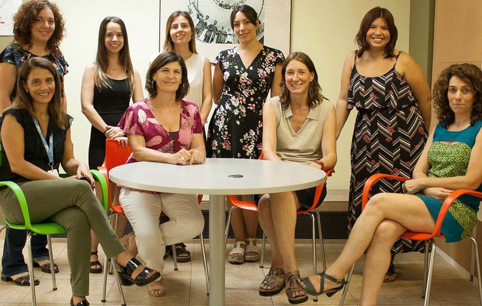Foto de un grupo de mujeres sentadas alrededor de una mesa; 4 sentadas y 5 de pie.
https://www.leloir.org.ar/wp-content/uploads/2019/02/Dia-Internacional-de-la-Mujer-y-la-Nin%CC%83a-en-la-Ciencia-Post-body.jpg