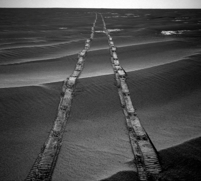 Foto de las huellas dejadas por Opportunity sobre arena gris.
mars2