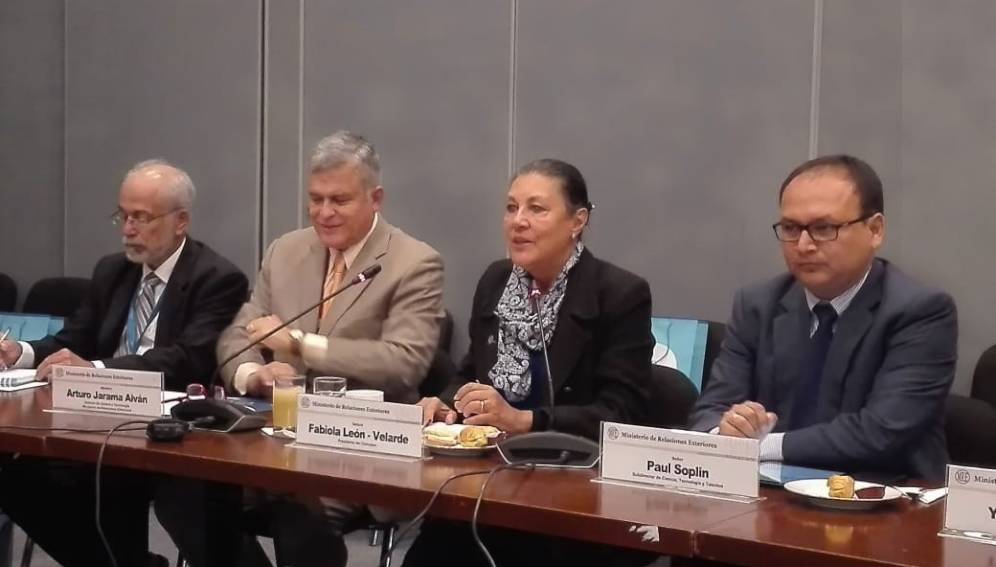 Tres personas sentadas en una mesa principal, Altas autoridades de ciencia y tecnología del gobierno peruano informado a la prensa extranjera en la sede de la cancillería.