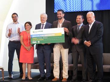 En la  foto posan de pie los representantes con el ganador; el Secretario Ejecutivo del CONICIT y el ganador de la Mención de Honor sostenienen el cheque que representa el premio.