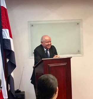 Foto del Dr. Chavarría en un podio exponiendo la charla.