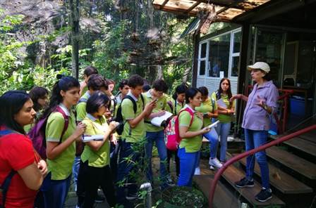 Foto del grupo de estudiantes con uniforme durante la visita al Museo, atentos a las indicaciones del guía.