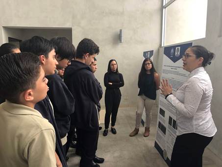 En la foto un grupo de estudiantes prestan atención a la exposición de uno de los proyectos en la Jornada de Investigación.