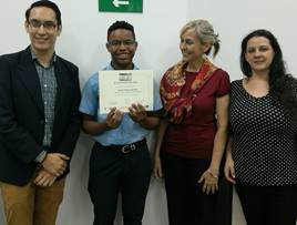 Foto donde posan Alejandra León, dos jurados y un ganador mostrando un certificado.