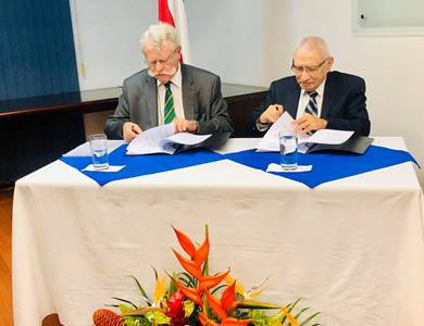 Foto de mesa principal, sentados se encuentran el Dr. Walter Fernández y un represetante de la Academia de Agricultura de Francia mientras firman el convenio.