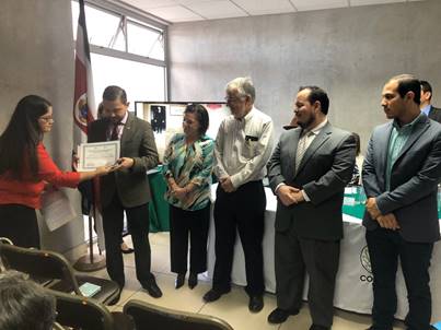 En la foto se muestran seis personas de pie, entre las cuales se encuentra el Ing. Luis Adrián Salazar Ministro de Ciencia, Tecnología y Telecomunicaciones recibiendo el certificado de ingreso a la Memoria del Mundo de los documentos del Dr. Clodomiro Picado.
