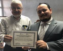 El Dr. Jose María Gutiérrez y un representante del Comité, ´posan mostrando el certificado. 