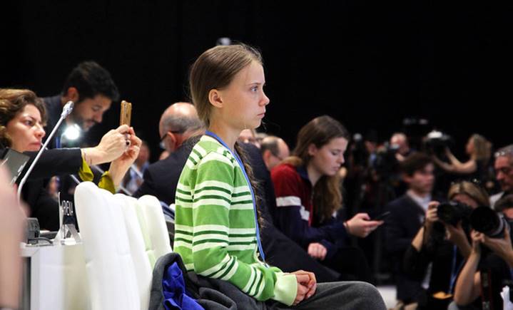 Greta Thunberg sentada entre el público prestando atención a las exposiciones de otros integrantes de COP25.