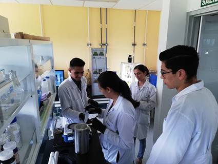 Foto del Dr. Sánchez mientras trabaja en el laboratorio junto a otros tres investigadores.