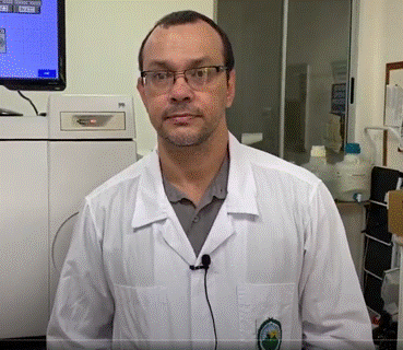 Foto del Dr. Guillermo León, de pie en un laboratorio; viste una bata blanca.