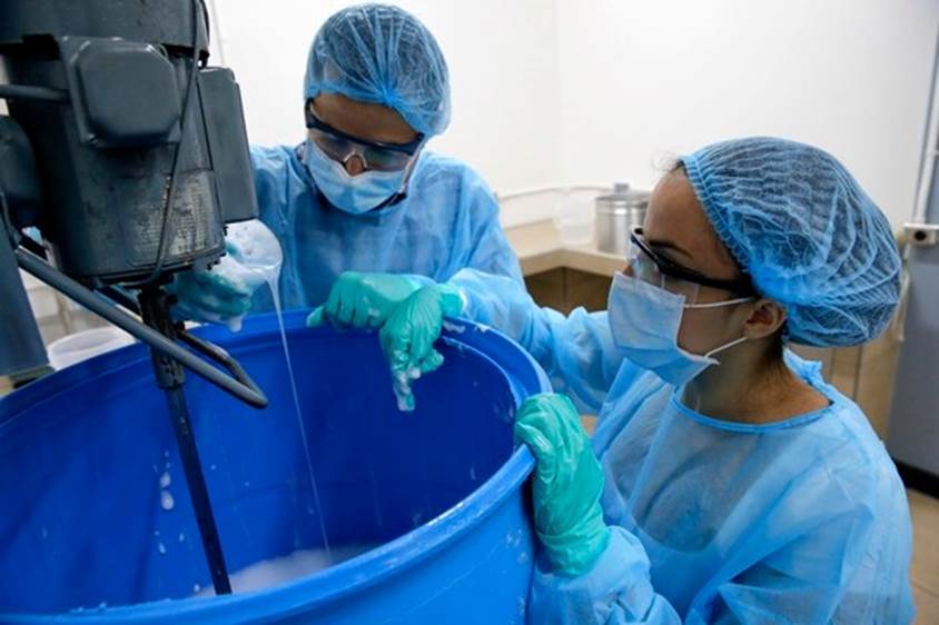 Viviana Pérez y José Roberto Vega trabajan en el proceso de producción de jabón líquido revisando el producto en la mezcladora. Fotos: Mayela López