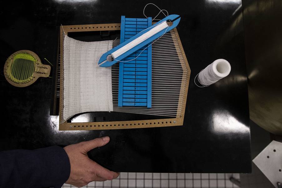 Gustavo Medina, investigador del Instituto de Ciencias Nucleares muestra un telar que se utiliza para construir parte del sistema que hará viajar nueve pequeños robots mexicanos a la Luna