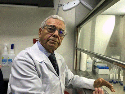 Foto del Dr. Chinchilla con gabacha blanca sentado en su laboratorio.