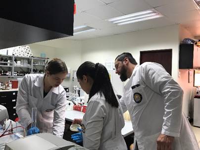 Tres estudiantes de la UCIMED en el laboratorio, trabajando.