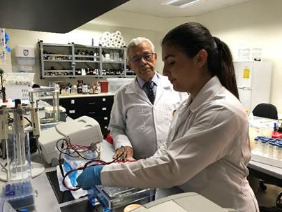 El Dr. Chinchilla junto a una estudiante, trabajando en el laboratorio.