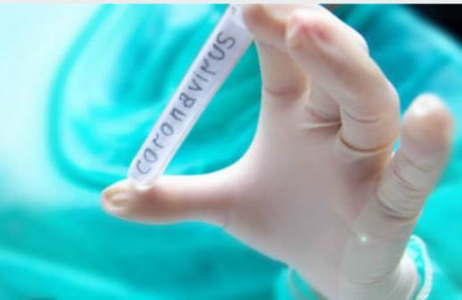 Foto ilustrativa, una mano con guante de látex muestra un tubo de ensayo con un rótulo que dice "coronavirus"