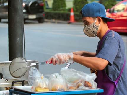 informalidad desigualdad América Latina Caribe coronavirus
Se muestra una persona con mascarilla haciendo venta de comidas en la vía pública